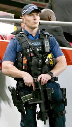 a police officer is standing in front of the stands with his arms crossed and looking at something