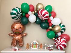 a gingerbread man is standing in front of a christmas wreath and decorations on the mantle