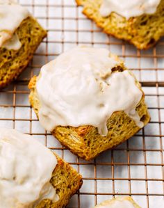 some type of bread with white icing on a cooling rack and another item in the background