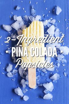 two ingredient pina colada popsicles on a blue background with broken ice chunks