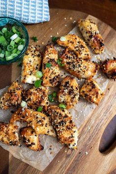 chicken with sesame seeds and green onions on a cutting board