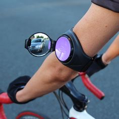 a close up of a person on a bike with their reflection in the side mirror