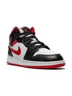 a pair of black and white sneakers with red accents on the upper half of the shoe