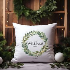 a white pillow sitting on top of a bed next to christmas decorations and greenery