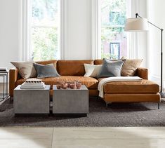 a living room with two couches and a coffee table in front of three windows