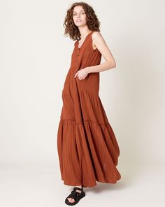 Raquel Allegra Roma Tiered Dress in rust cotton gauze medley. Airy, tiered floor-length dress in lofty gauze. Sleeveless silhouette with empire waistline and billowy silhouette balances romance with realism. Three button placket at front. Raw edge seam detailing at lowere tier. Fit: True to size Material: Cotton Origin: Los Angeles Care: Gentle wash Model: Catherine (5'11", 24" waist, 35" hip, 34B) wears a size 1 Why we Covet: Informal beauty Shown here with: Hereu Beltra in Black Empire Waistline, Raquel Allegra, Rust Dress, Floor Length Dresses, Tiered Dress, Raw Edge, Button Placket, Floor Length, Long Dress