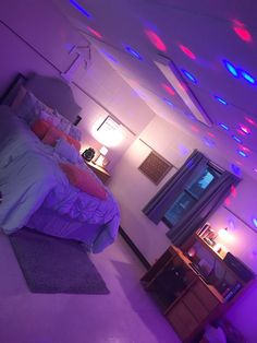 a bedroom with purple and red lights on the ceiling