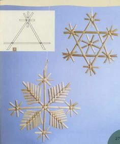 an ornament made out of popsicle sticks is hanging from a line and has snowflakes attached to it