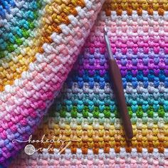 a crocheted blanket with a pen laying on it