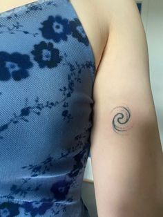 a woman's arm with a tattoo on it that is shaped like a spiral