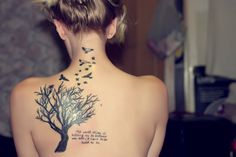 a woman with a tree and birds on her back