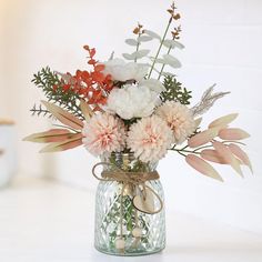 a vase filled with lots of flowers on top of a table