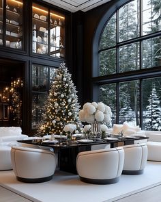 a living room with white furniture and a christmas tree in the window sill next to it