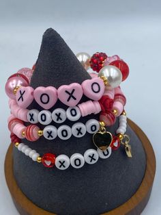 a stack of bracelets on top of a hat with beads and charms around it