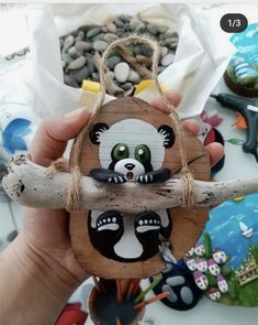 a person holding up a piece of wood that looks like a panda on a branch