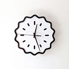 a black and white clock on the wall with no numbers in it's face