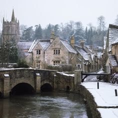 a river running through a small town with snow on the ground