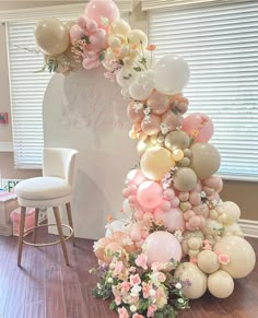 the balloon arch is decorated with flowers and balloons