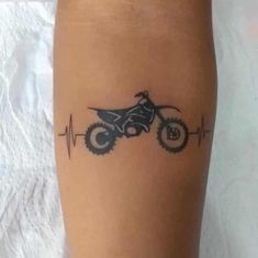 a person with a tattoo on their leg that has a dirt bike drawn on it