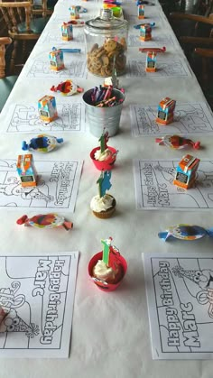 a long table with cupcakes and candy on it