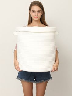 a young woman holding a large white object in her hands and posing for the camera