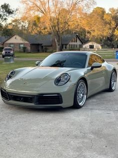 a silver sports car parked in front of a house