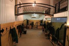 the inside of a horse stable with several stalls