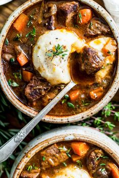 two bowls filled with beef stew and potatoes