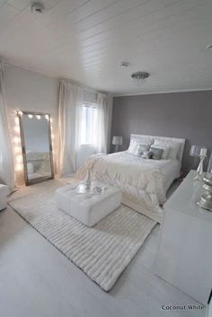 a bedroom with white furniture and gray walls