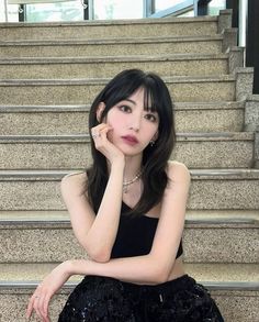 a woman sitting on the steps with her hand under her chin