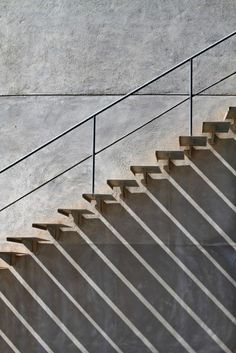 a man riding a skateboard down the side of a set of stairs next to a cement wall