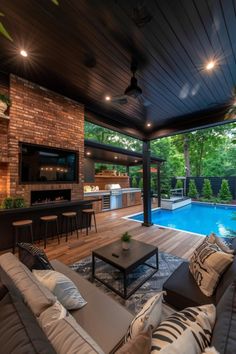 a living room with couches and a table next to a swimming pool