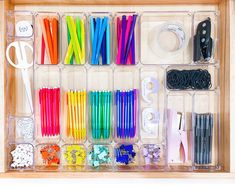 a drawer filled with lots of different colored pens and pencils on top of it