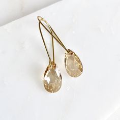 These gleaming crystal pear drops dangle elegantly on plated kidney wires for a total length of 1.75". The teardrop shape has a breathtaking shine, perfect for any occasion. A picture of the same design in a different hue is provided for reference. Ships Free • Handmade in the USA Luxury Yellow Gold Teardrop Earrings Fine Jewelry, Elegant 14k Gold-filled Teardrop Earrings, 14k Gold Filled Elegant Teardrop Earrings, Crystal Teardrop Earrings With Pearl Drop, Pearl Drop Teardrop Crystal Earrings, Pear-shaped Teardrop Earrings For Party, Gold Teardrop Crystal Earrings, Teardrop Crystal Earrings For Party, Nickel-free Yellow Gold Teardrop Earrings