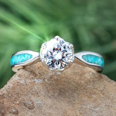 A brilliant moissanite sits atop this sleek platinum engagement ring. Crushed turquoise perfectly complements the moissanite stone, allowing the color to shine throughout this unique ring. Need a matching wedding band for your unique engagement ring? Our Platinum and Diamond Women's Wedding Band (SKU 3885PT) pairs perfectly with this design. RING LAYOUTRing Width: 3.5 mmRing Sleeve: PlatinumRing Profile: RoundRing Finish: Polished 0.75 mm Platinum2 mm Crushed Kingman Blue Turquoise0.75 mm Platin Luxury Turquoise Diamond Ring With Center Stone, Promise Ring In Turquoise Sterling Silver, Gift Turquoise Diamond Ring With Center Stone, Gift Turquoise Ring With Diamond Center Stone, Turquoise Diamond Anniversary Ring, Turquoise Diamond Rings With Center Stone, Diamond And Turquoise Engagement Ring, Turquoise Ring With Center Stone For Anniversary, Anniversary Turquoise Ring With Center Stone