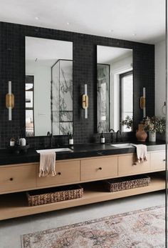 a bathroom with two sinks, mirrors and rugs on the floor in front of it