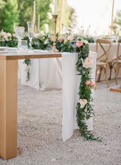 a table with flowers and candles on it is set up for an outdoor wedding reception