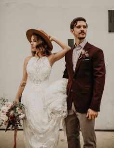 a man in a suit and tie standing next to a woman wearing a wedding dress