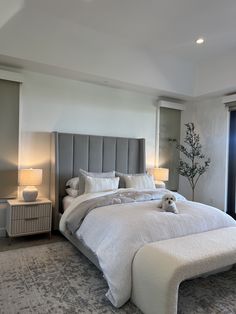 a bedroom with a large bed and two lamps on either side of the headboard