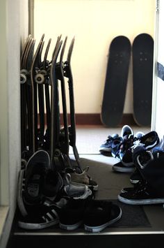 there are many pairs of shoes and skateboards on the floor