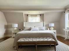 a bedroom with a large bed and white furniture