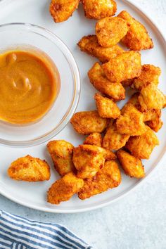 some fried food on a white plate with dipping sauce