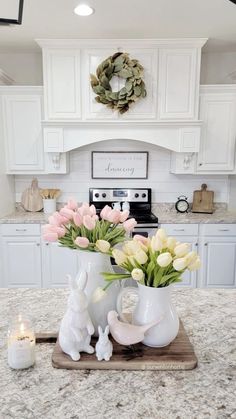 a kitchen counter with flowers in vases on top of it and candles next to it