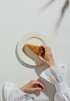 a person holding a piece of pie on a plate