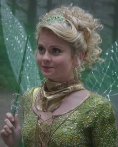 a woman dressed in green holding an umbrella