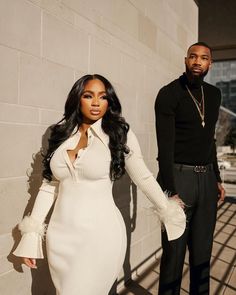 a man standing next to a woman in a white dress