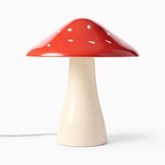 a red mushroom lamp sitting on top of a white table