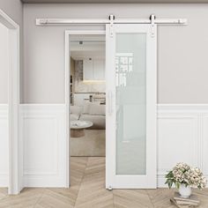 an open door leading to a living room with white walls and parquet flooring