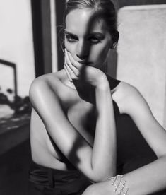 black and white photograph of a woman with her hand on her face, sitting down