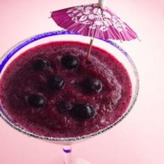 a blueberry smoothie in a glass with an umbrella